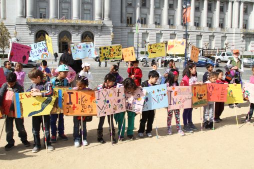 Children holding posters outside San Francisco City Hall.