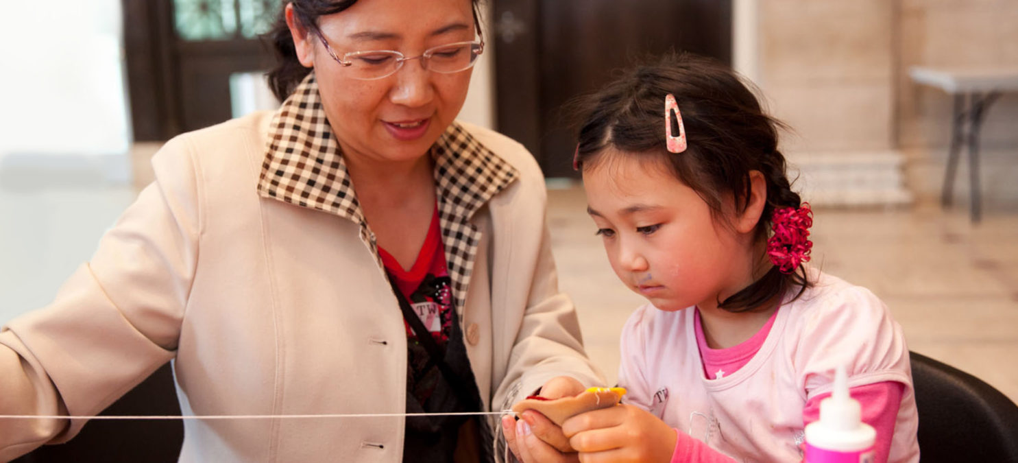 A woman and a child doing a craft.