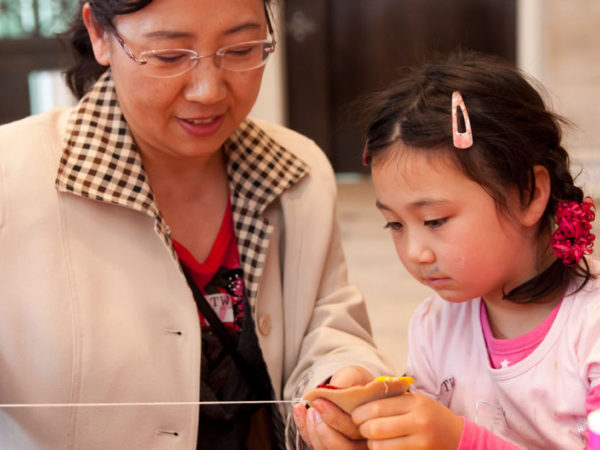 A woman and a child doing a craft.