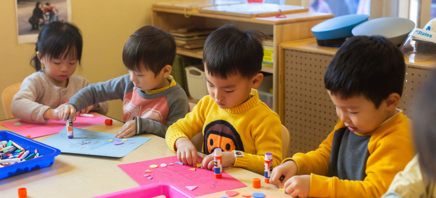 Four small children doing a craft.