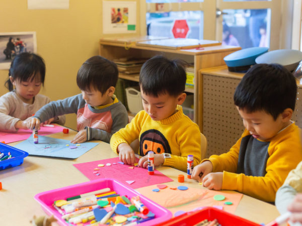 Four small children doing a craft.